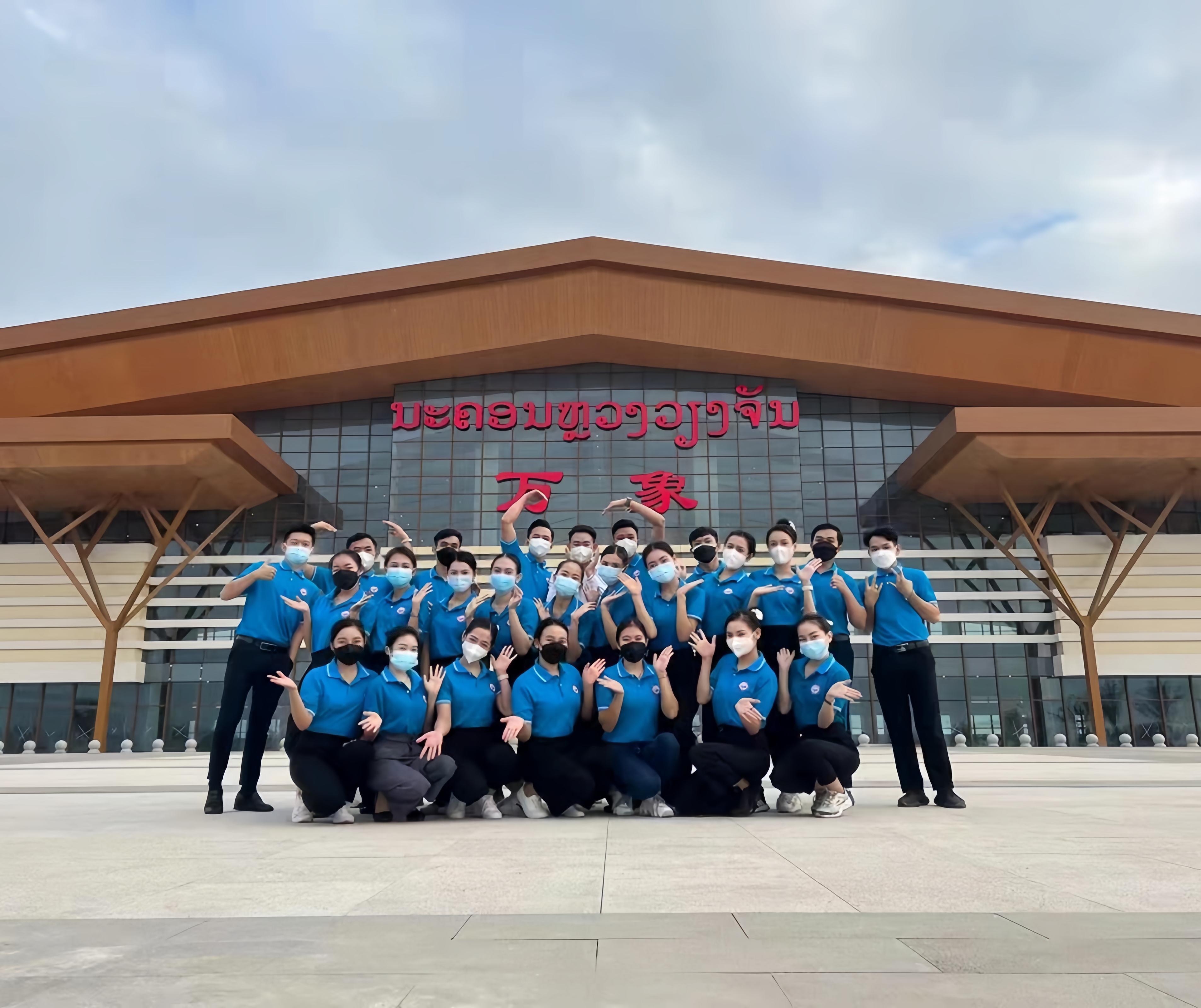 學(xué)生上崗前在老撾萬(wàn)象高鐵站前合影（其中5人為貴陽(yáng)職業(yè)技術(shù)學(xué)院培訓(xùn)班學(xué)生）。 貴陽(yáng)職業(yè)技術(shù)學(xué)院供圖