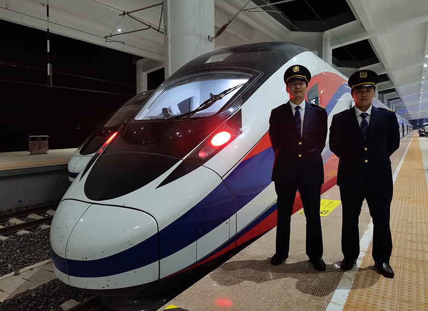 劉銀能（右一）與中國師父鄔俊鴻在動(dòng)車組前合影。受訪者供圖