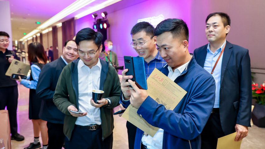 人民網(wǎng)研發(fā)推出的《人民日?qǐng)?bào)》生日?qǐng)?bào)吸引嘉賓體驗(yàn)。主辦方供圖